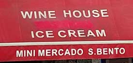 Red market awning with white letters "Wine House and Ice Cream" on market in Lisbon Portugal