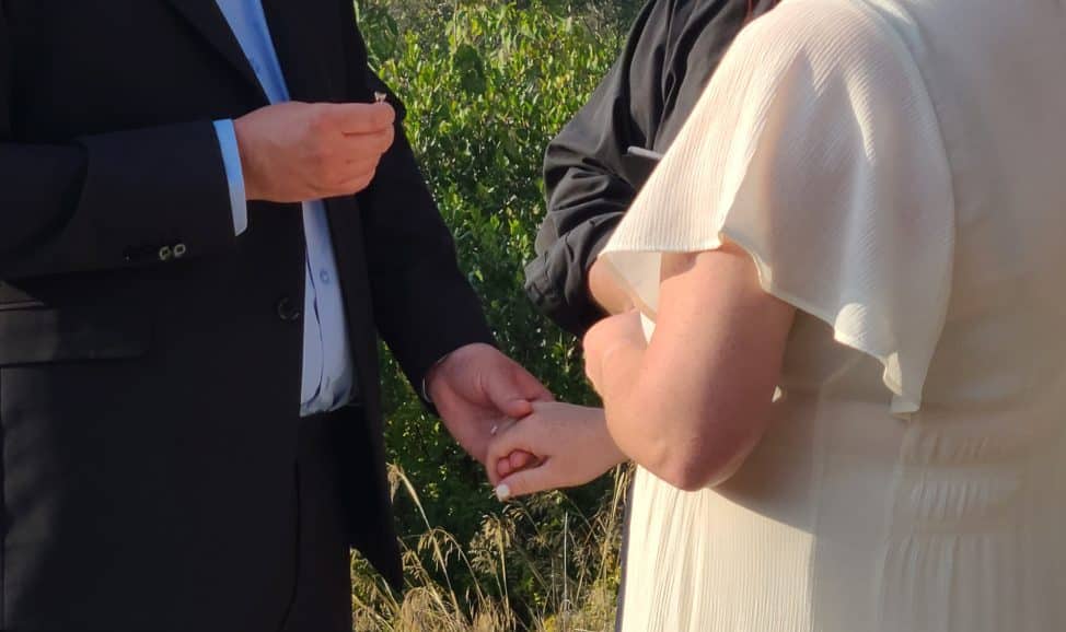 Groom about to slip ring on bride's finger