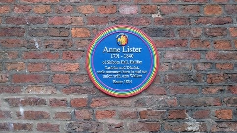 rainbow circled plaque by LGBT Civic Trust reading "Anne Lister 1791-1840 of Shibden Hall, Halifax. Lesbian and Diarist; took sacrament here to seal her union with Ann Walker Easter 1834" Photo courtesy of AstronomyBlog