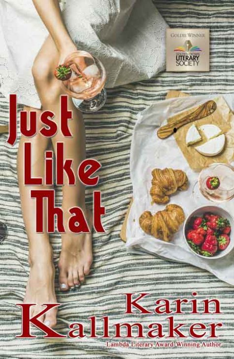 Cover Just Like That 2023 by Karin Kallmaker a picnic features the long legs of a tanned woman holding a glass of wine