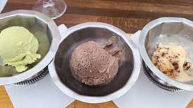 three small dishes of single scoops with pistachio, oreo cookie, and salted dark chocolate caramel