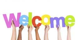 hands in all the colors of the human rainbow hold up the letters that spell WELCOME