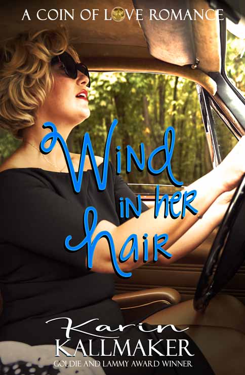 A forty-something blonde white woman in a simple black dress that reveals her neck and shoulders is driving an old-fashioned car as sun streams onto her through the windshield. "A Coin of Love Romance, Wind in Her Hair, Goldie and Lammy Winner Karin Kallmaker"