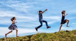 kids running and leaping on hillside