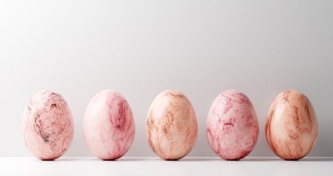 5 pink and white marble easter eggs on white background